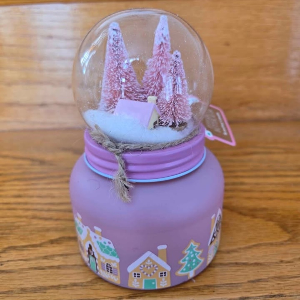 Candle with snow globe on top